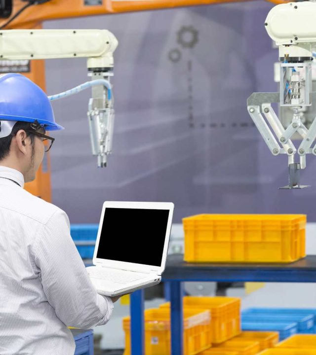 Automatización-Industrial The mechanical engineer control robot arm in manufacturing factory. Industrial 4.0 concept.Modern technology for manufacturing